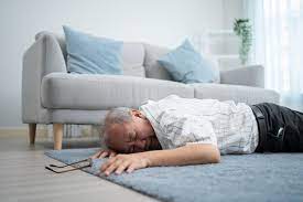 A man laying on the floor in front of a couch.